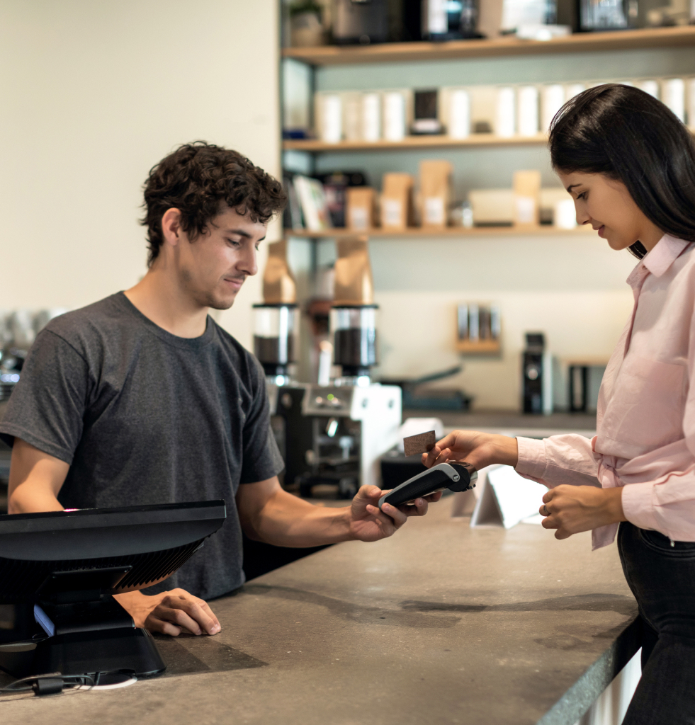 A coffee shop owner assisting a paying customer